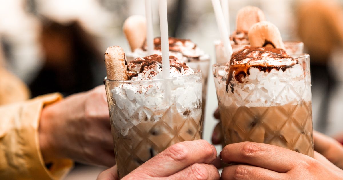 Two people holding iced coffees