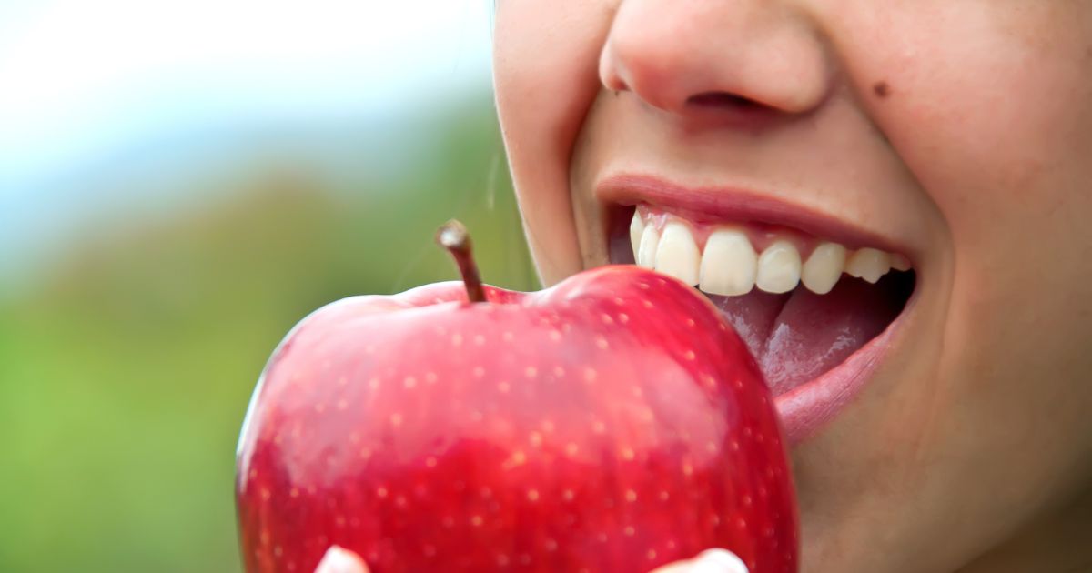 Woman biting into a fresh apple