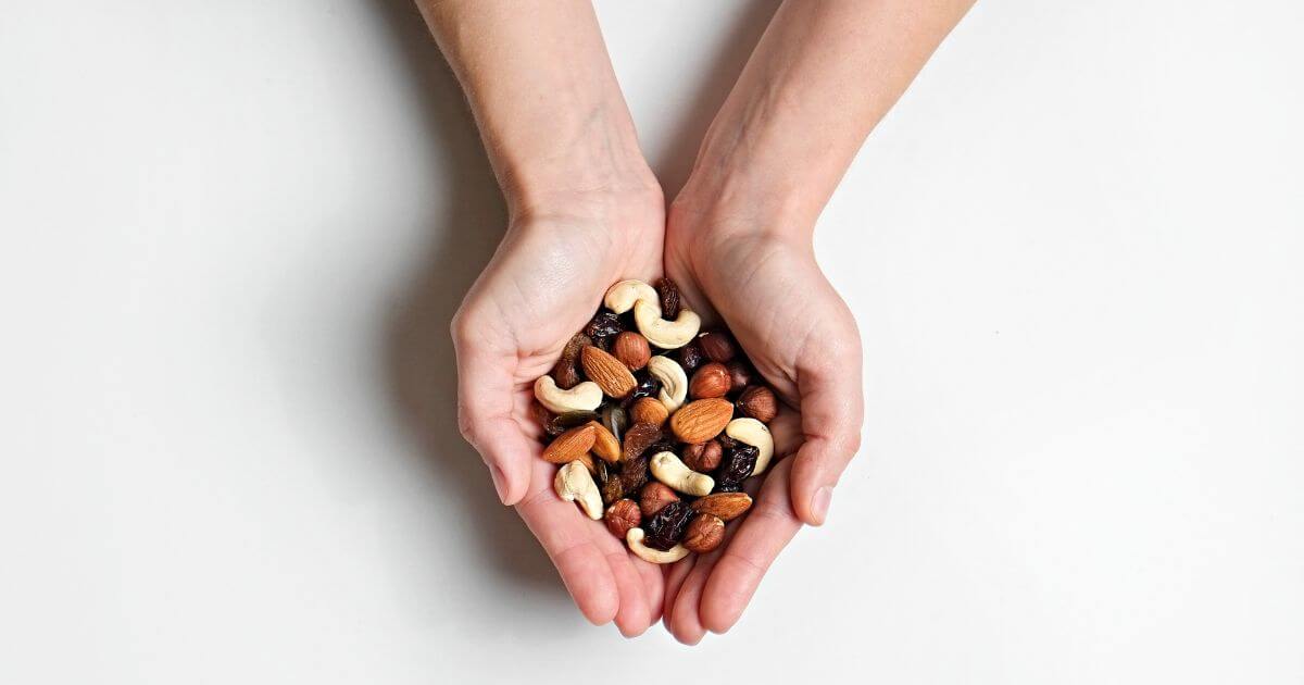 Hands holding a pile of mixed nuts