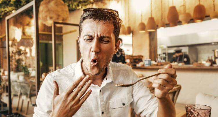 Man eating a forkful of spicy food