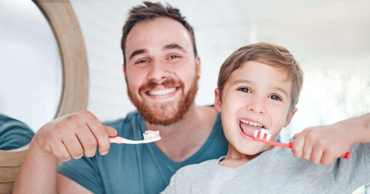 Father and young son brushing their teeth together