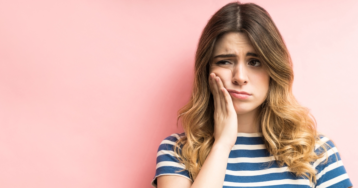 Woman holding the side of her face in pain
