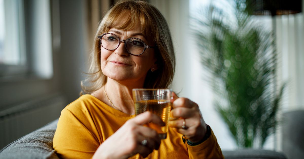 Woman smiling while drinking a cup of green tea