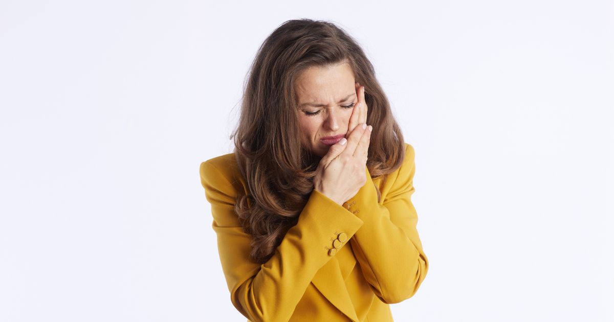 Woman holding her jaw in discomfort