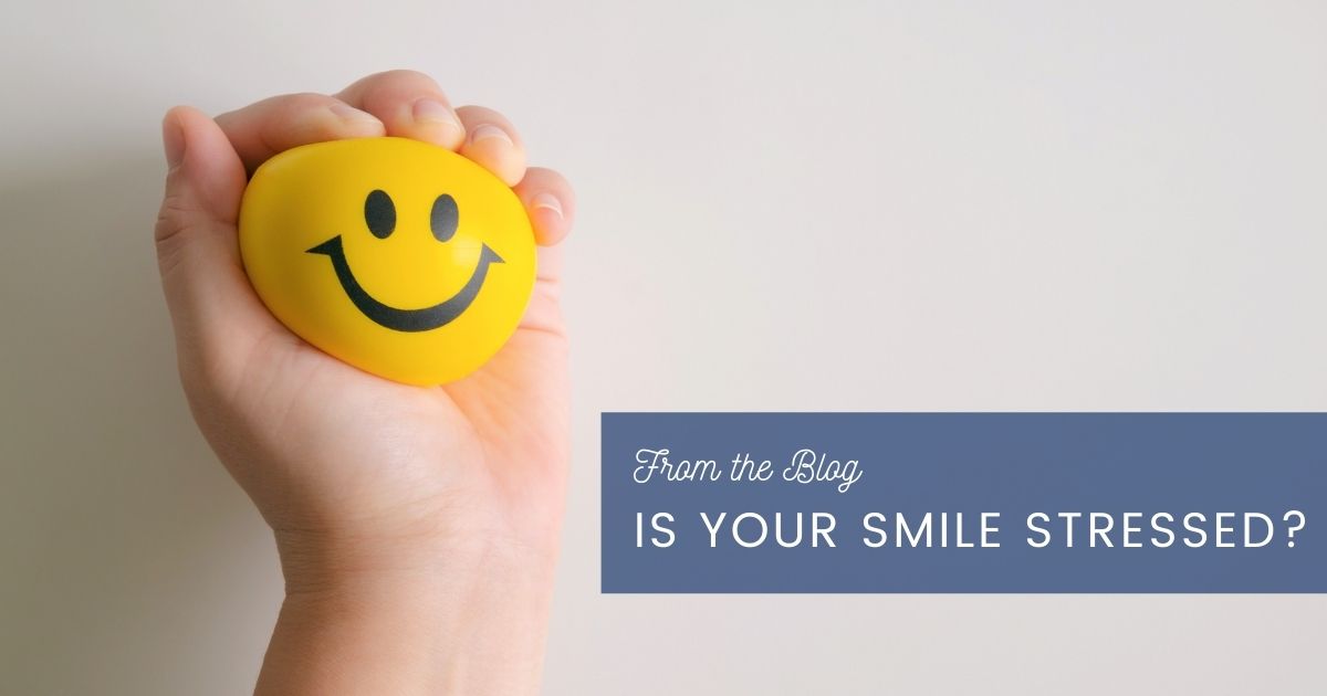 Smiley-face stress ball being squeezed