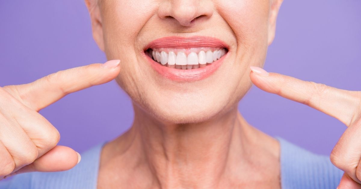 Woman pointing to her smile