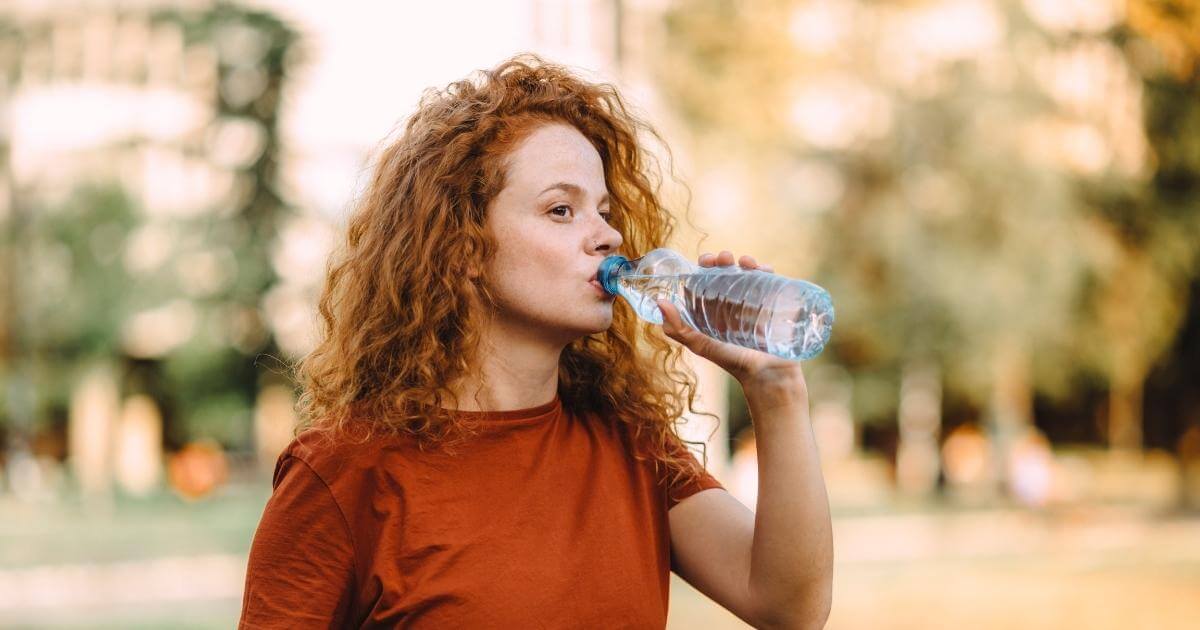 Woman sipping water from a bottle