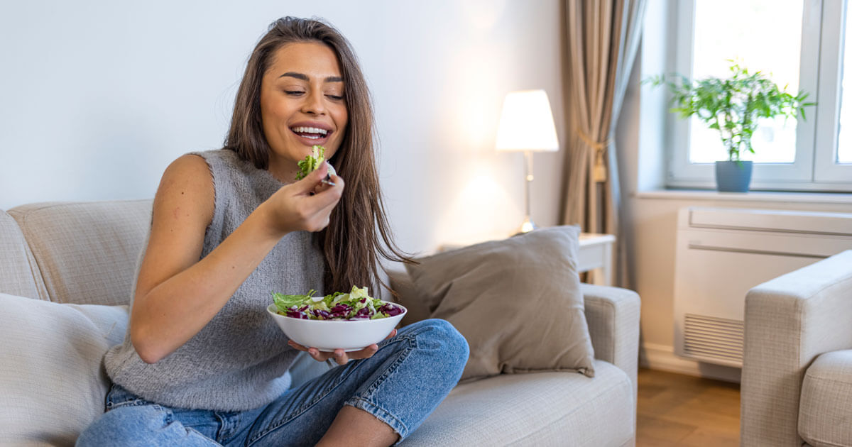 Woman eating a fresh, leafy green salad