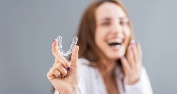 Woman holding a clear aligner