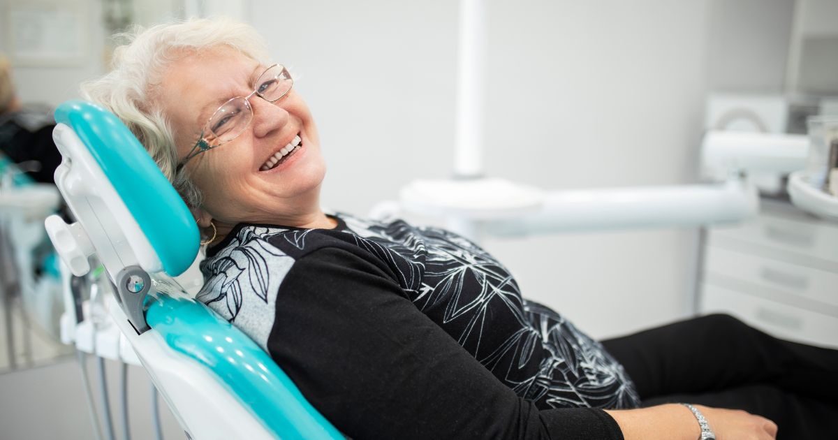 Woman smiling comfortably in a dental chair
