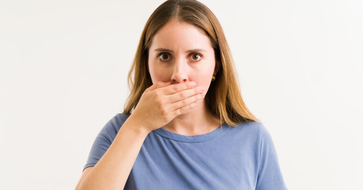 Woman covering her mouth with her hand