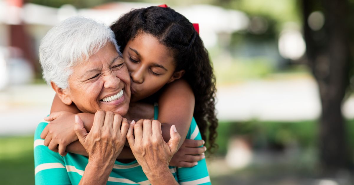 Granddaughter hugging her smiling grandmother