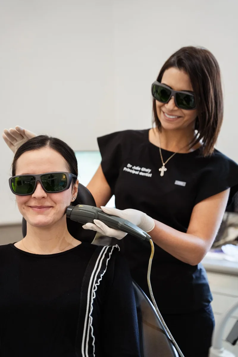 Dr Julie Ghaly applying MLS laser therapy to a patient's jaw at TMJ Therapy Centre Toorak